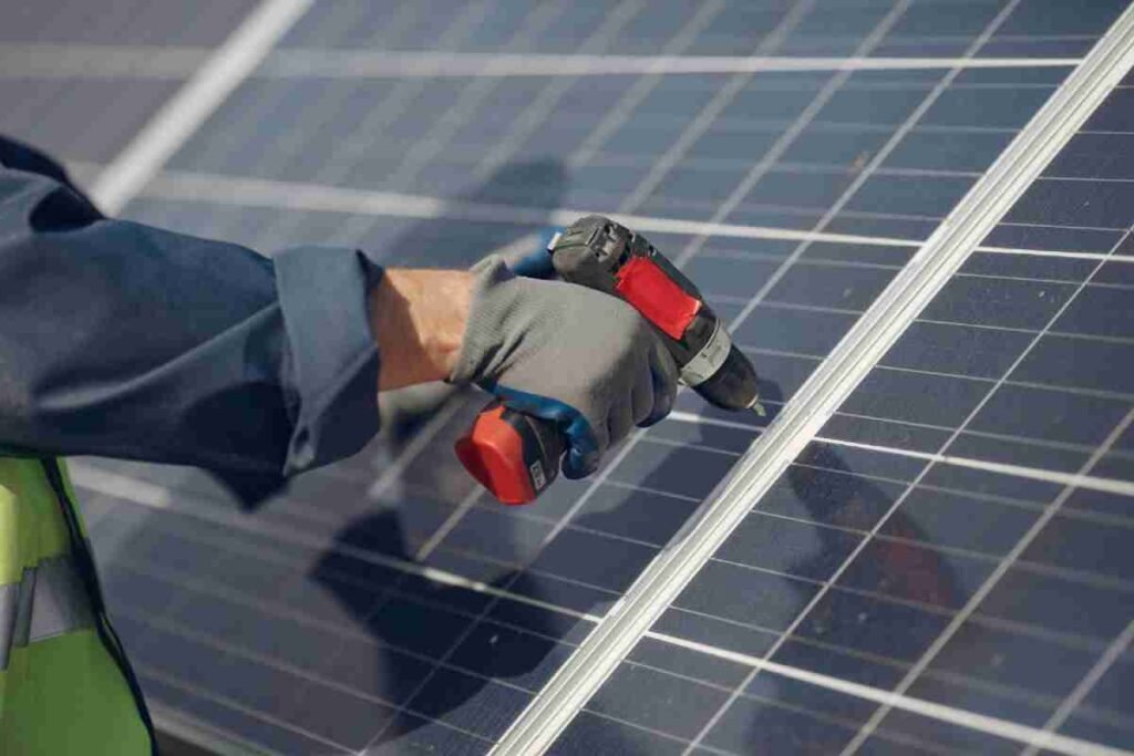 a man with tools doing solar installation
